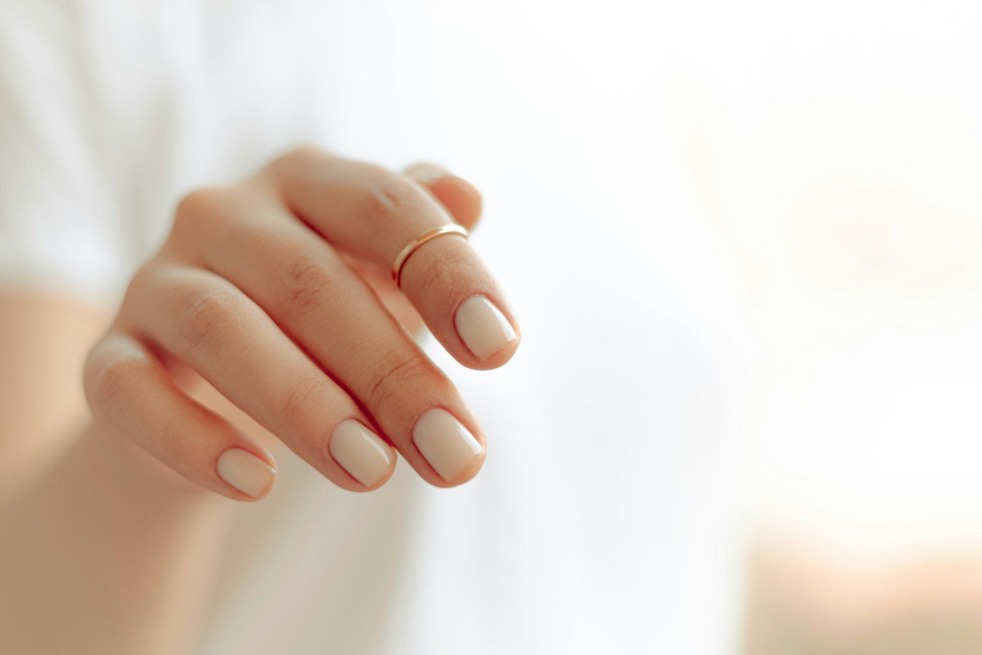 Imagen de referencia: mano con uñas cuidadas sobre fondo claro